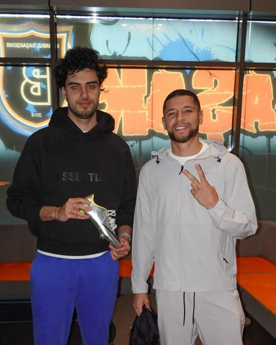 Footballer holding a pair from Boots Plug