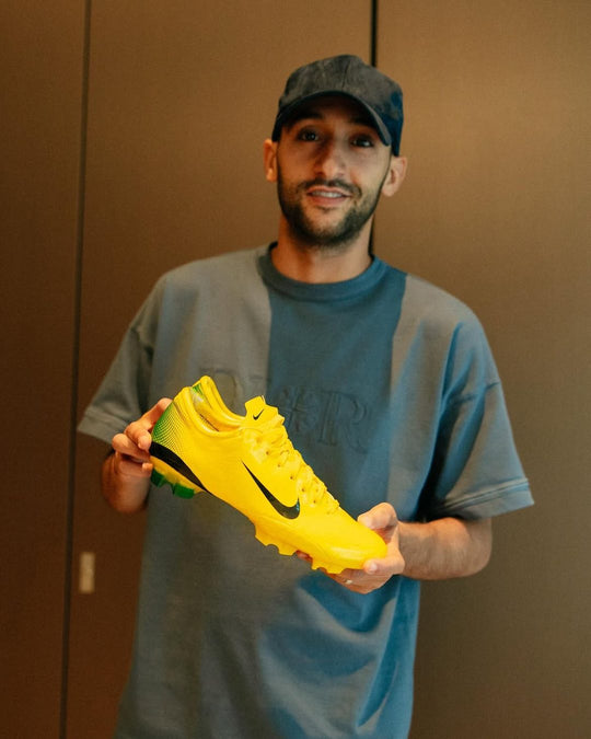Footballer holding a pair from Boots Plug