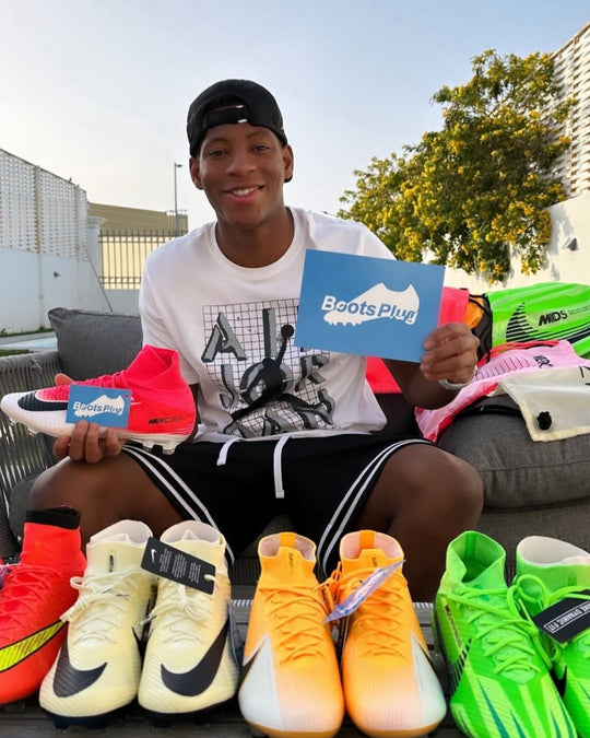 Footballer holding a pair from Boots Plug