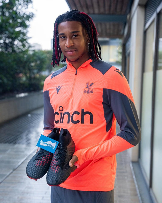 Footballer holding a pair from Boots Plug