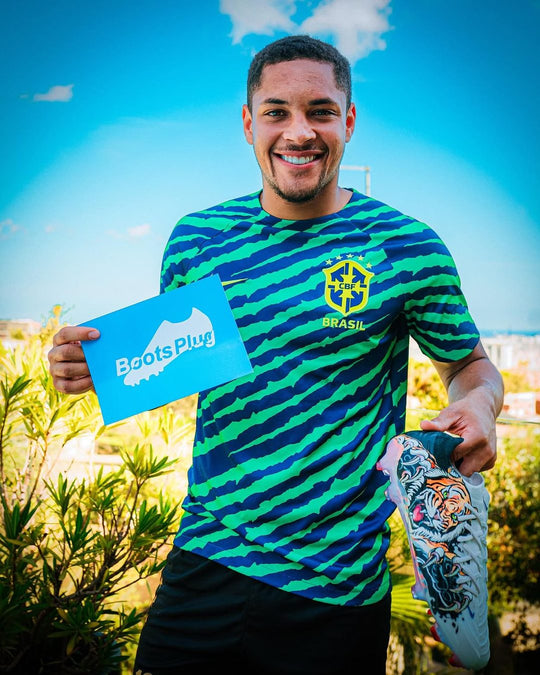Footballer holding a pair from Boots Plug