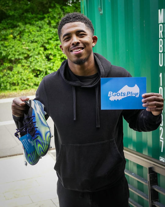 Footballer holding a pair from Boots Plug