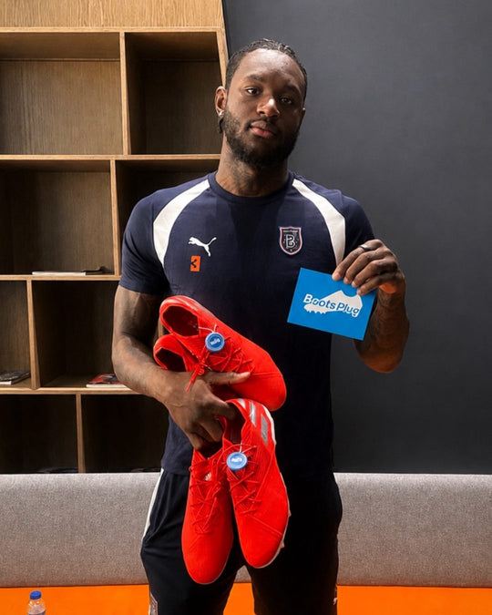 Footballer holding a pair from Boots Plug